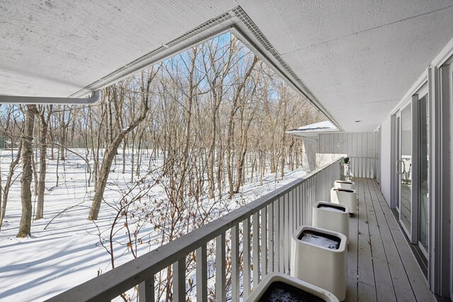 view of snow covered back of property