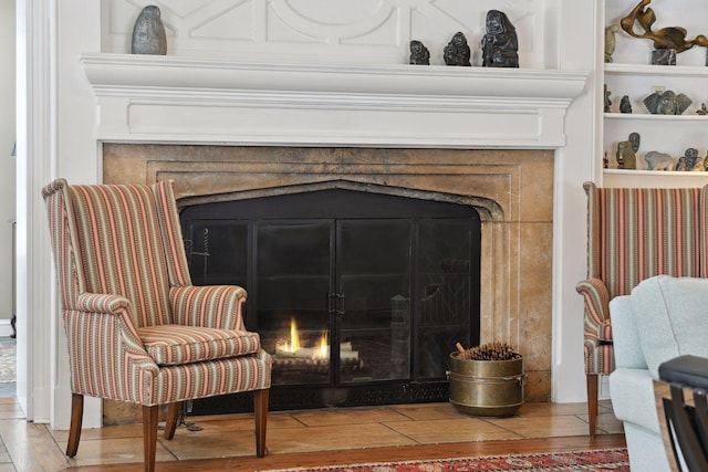 room details with a fireplace with flush hearth and wood finished floors