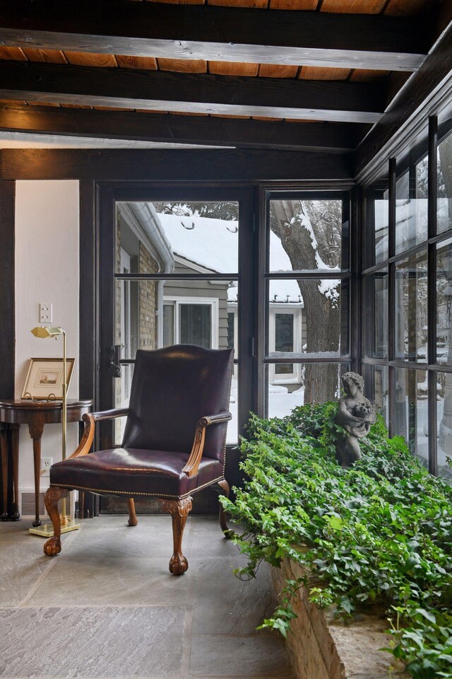 sunroom featuring beam ceiling