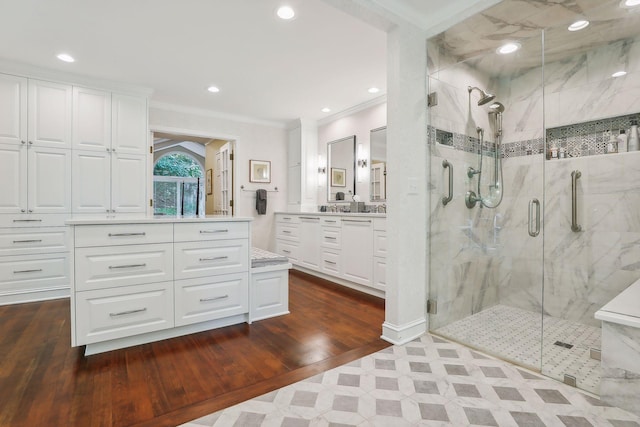 bathroom with a marble finish shower, ornamental molding, wood finished floors, vanity, and recessed lighting