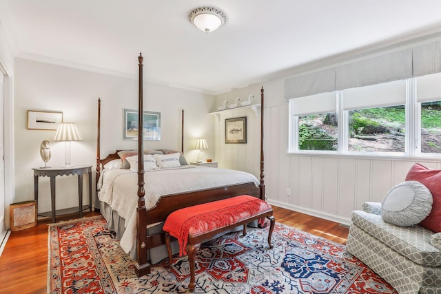 bedroom with ornamental molding and wood finished floors