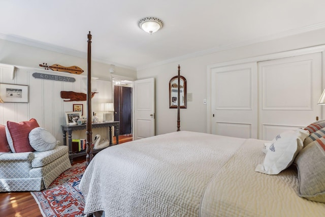 bedroom with a closet, wood finished floors, and crown molding