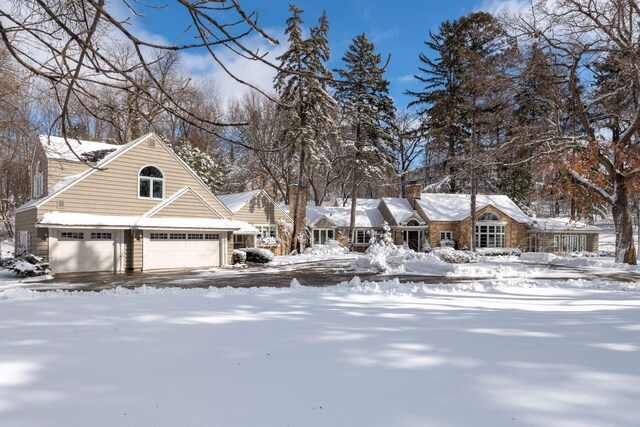 view of front facade with a garage and a chimney