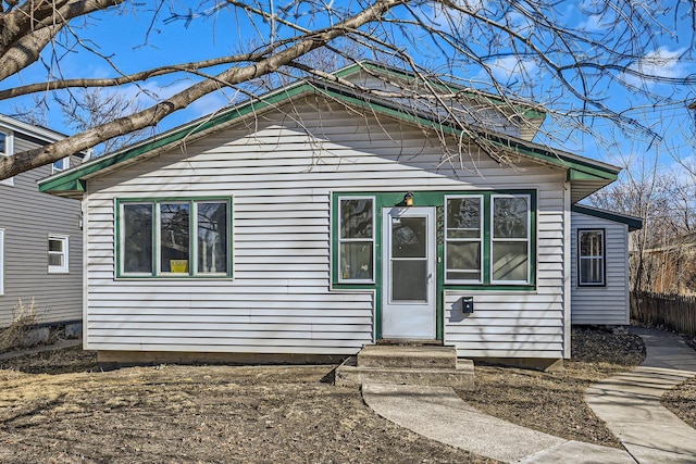 bungalow-style house with entry steps and fence