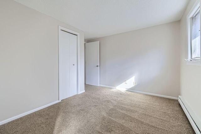 unfurnished room featuring carpet floors, baseboard heating, and baseboards