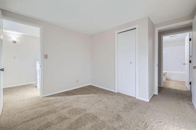 unfurnished bedroom featuring carpet floors, a closet, visible vents, and baseboards