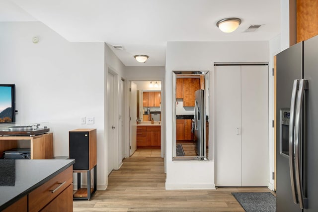 929 Portland Ave Unit 309, Minneapolis, MN 55404 - kitchen with stainless steel fridge, light wood-style flooring, and dark countertops