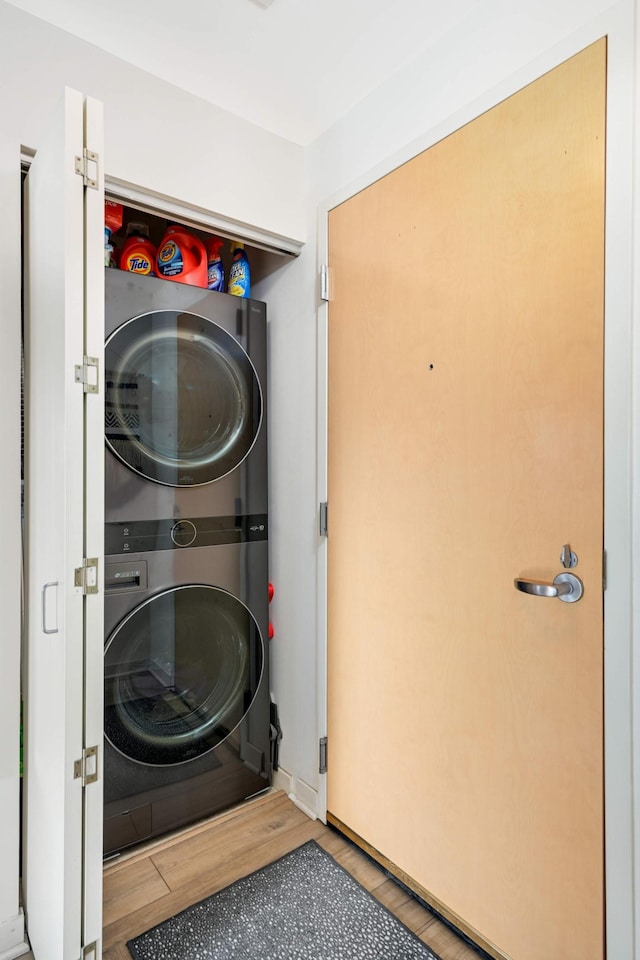 929 Portland Ave Unit 309, Minneapolis, MN 55404 - washroom featuring estacked washer and dryer and wood finished floors