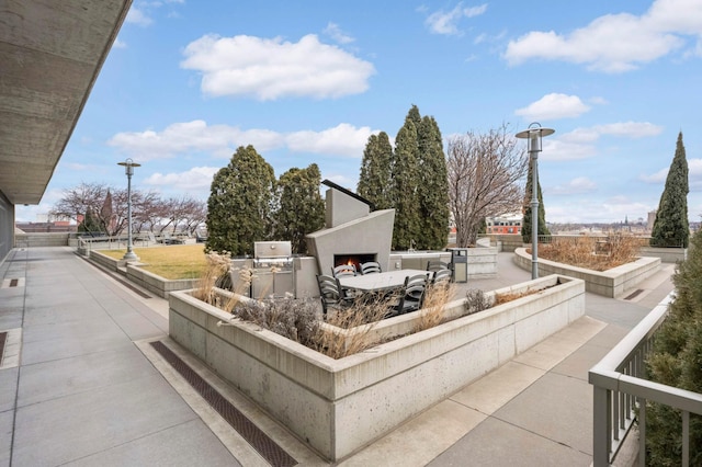 929 Portland Ave Unit 309, Minneapolis, MN 55404 - view of patio featuring exterior kitchen and a lit fireplace