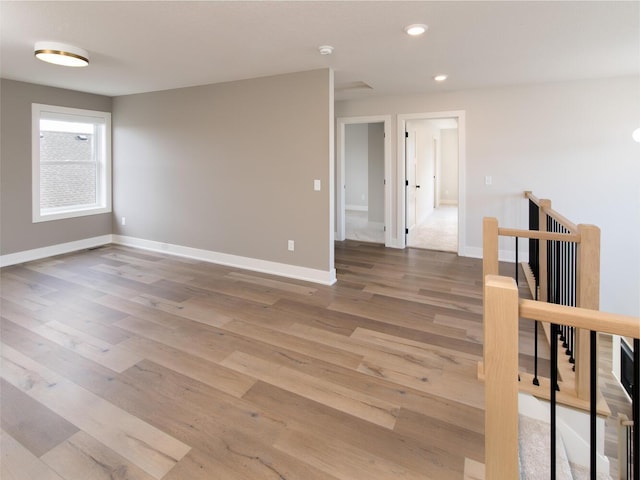 unfurnished room with baseboards, wood finished floors, and recessed lighting