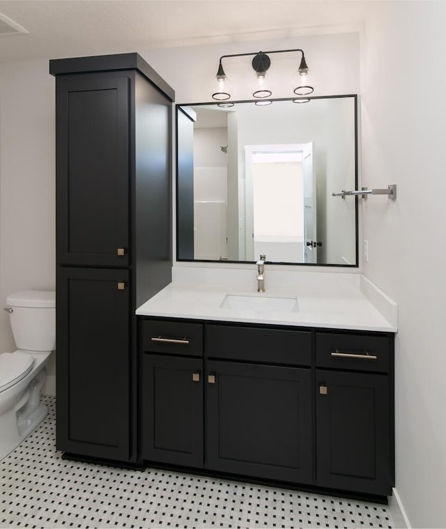 bathroom with toilet, baseboards, and vanity