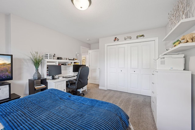 bedroom featuring a textured ceiling, a closet, and light carpet