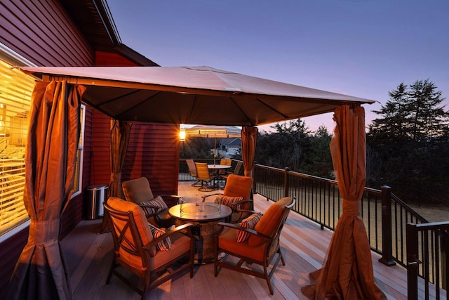 wooden deck featuring a gazebo and outdoor dining area