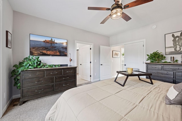 bedroom featuring light colored carpet, a ceiling fan, and baseboards