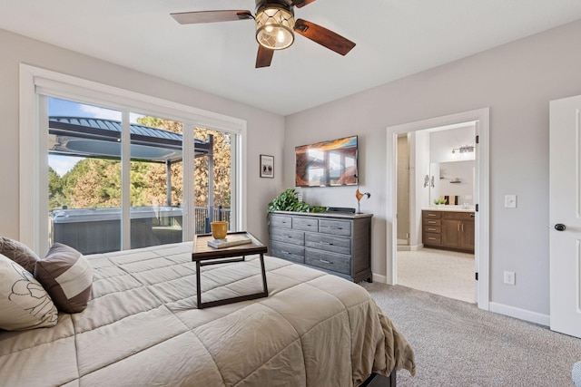 carpeted bedroom with ensuite bath, baseboards, and ceiling fan