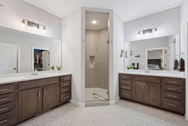 full bathroom featuring a sink, two vanities, and a stall shower