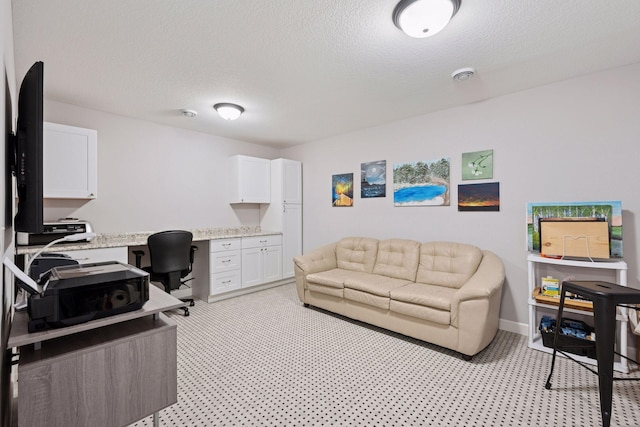 home office with baseboards, a textured ceiling, and built in study area