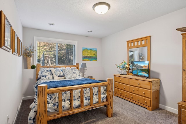 carpeted bedroom featuring a textured ceiling and baseboards