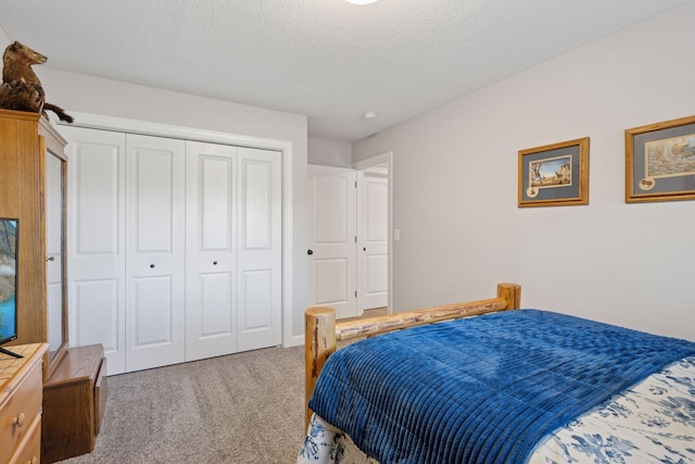 carpeted bedroom featuring a closet and a textured ceiling