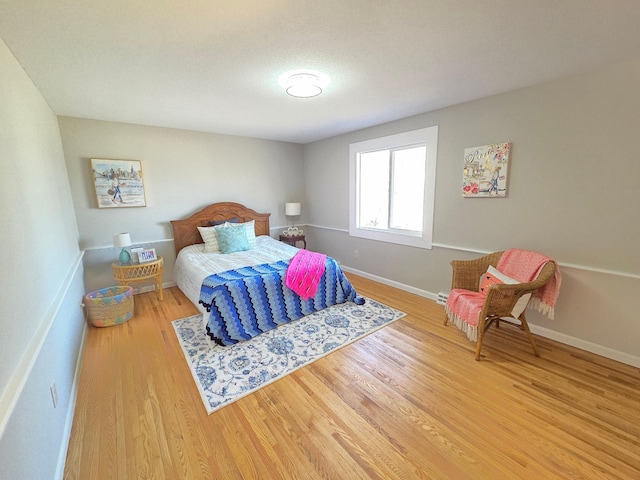 bedroom featuring baseboards and wood finished floors