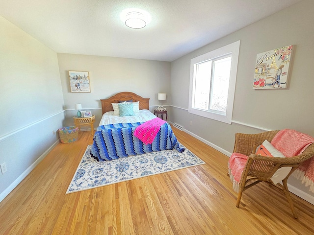 bedroom with baseboards and wood finished floors