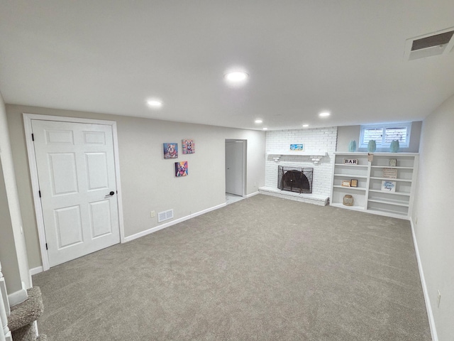 basement with baseboards, visible vents, carpet floors, a brick fireplace, and recessed lighting