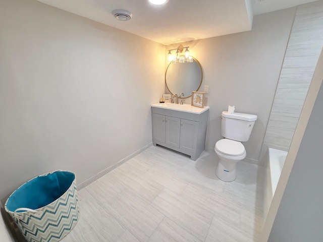 bathroom featuring visible vents, toilet, vanity, baseboards, and a bath