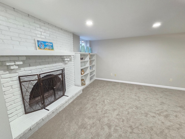 unfurnished living room with carpet floors, recessed lighting, a fireplace, and baseboards