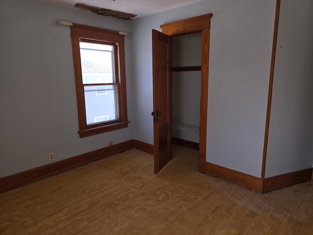 unfurnished bedroom featuring a baseboard heating unit and baseboards