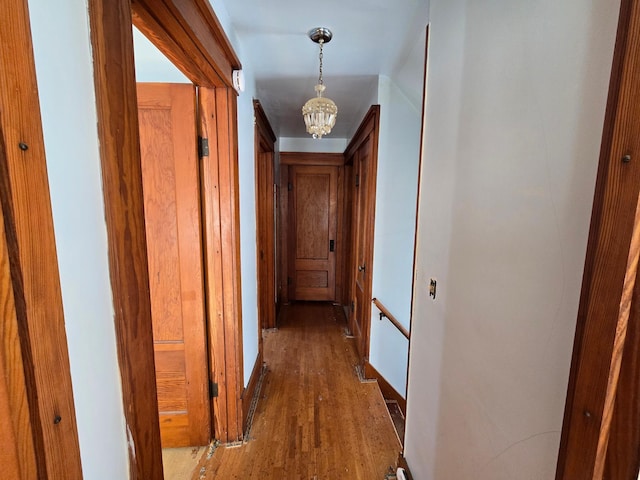 hallway featuring a chandelier and wood finished floors