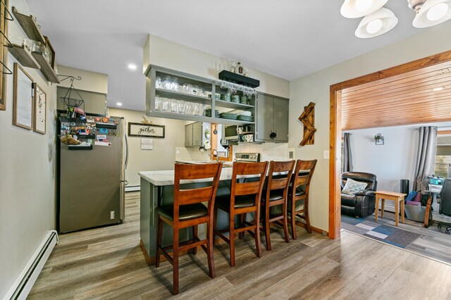 1422 24th Ave S, Moorhead, MN 56560 - indoor wet bar with a baseboard heating unit, appliances with stainless steel finishes, light wood-type flooring, baseboard heating, and recessed lighting
