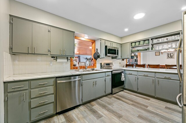 1422 24th Ave S, Moorhead, MN 56560 - kitchen with appliances with stainless steel finishes, light wood-type flooring, light countertops, decorative backsplash, and green cabinetry