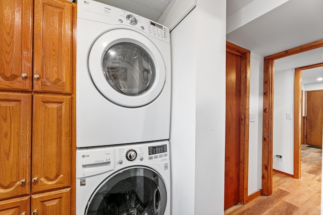 1422 24th Ave S, Moorhead, MN 56560 - laundry room with cabinet space, estacked washer and dryer, and light wood-style flooring