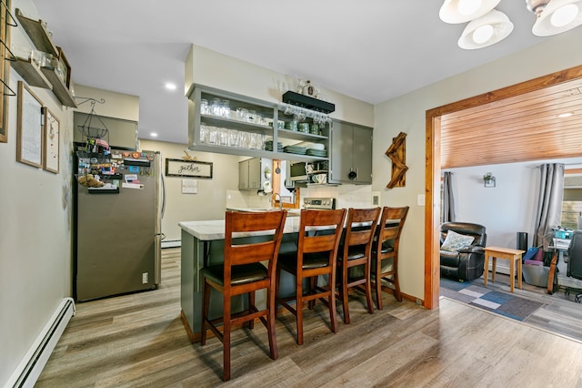 1422 24th Ave S, Moorhead, MN 56560 - indoor wet bar featuring baseboard heating, appliances with stainless steel finishes, light wood-style flooring, and recessed lighting