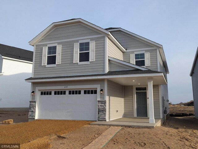 view of front of property featuring stone siding and an attached garage