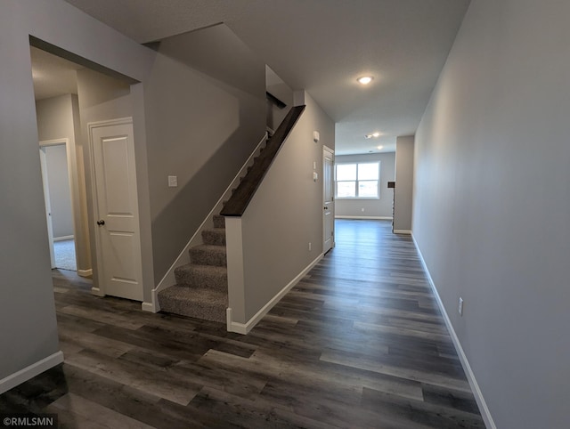 corridor featuring recessed lighting, stairway, baseboards, and dark wood finished floors