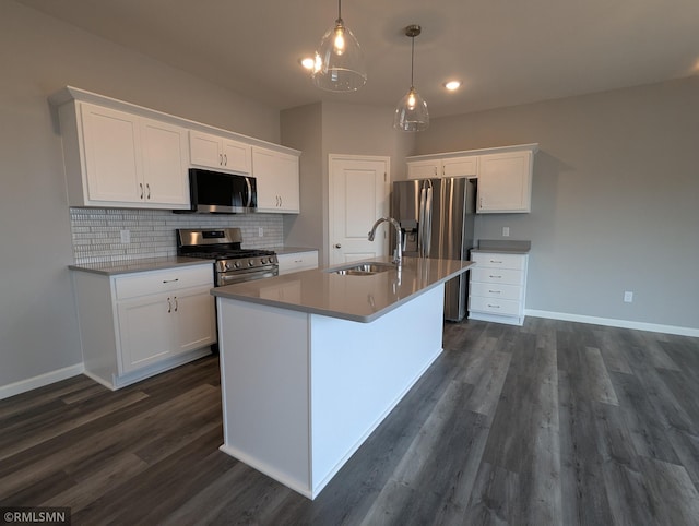 kitchen featuring backsplash, an island with sink, appliances with stainless steel finishes, white cabinets, and a sink