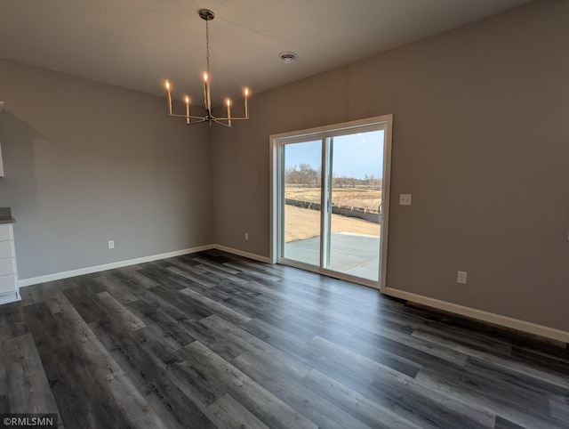 unfurnished dining area with dark wood-style floors, baseboards, and a chandelier