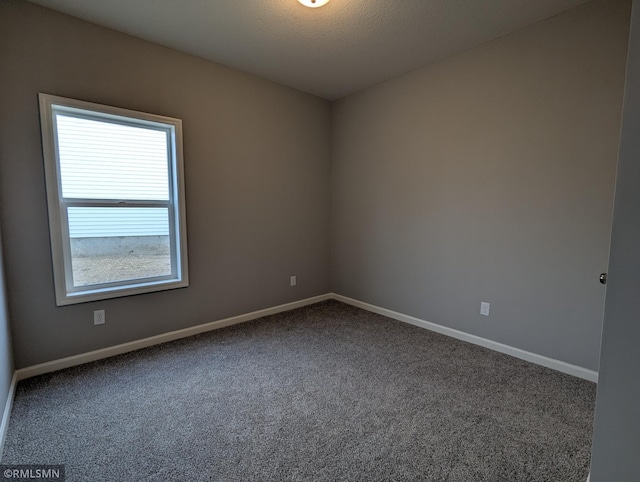 empty room featuring baseboards, carpet, and a textured ceiling