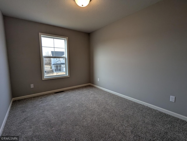 empty room featuring visible vents, a textured ceiling, baseboards, and carpet