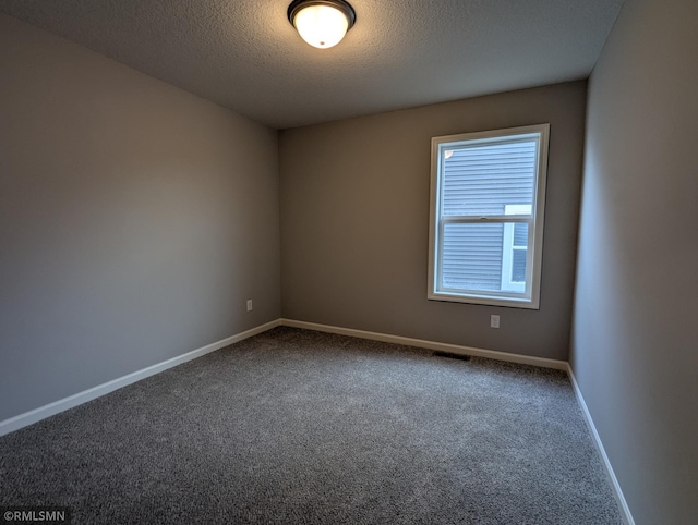 empty room with visible vents, baseboards, carpet, and a textured ceiling