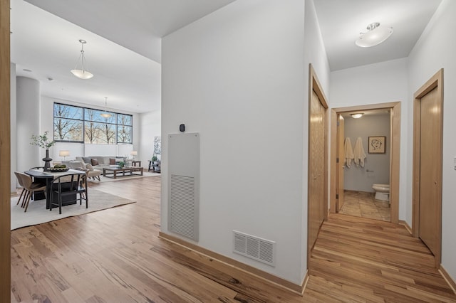 corridor featuring visible vents and light wood finished floors