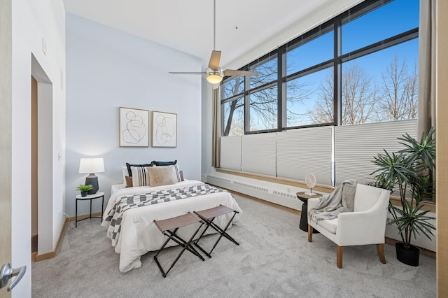 bedroom featuring a baseboard heating unit, carpet, baseboards, and a ceiling fan