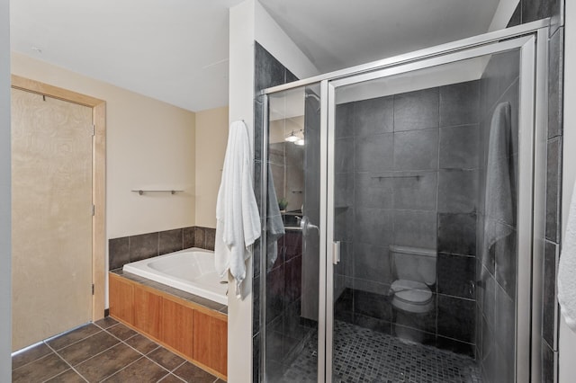 bathroom featuring toilet, a stall shower, a bath, and tile patterned floors