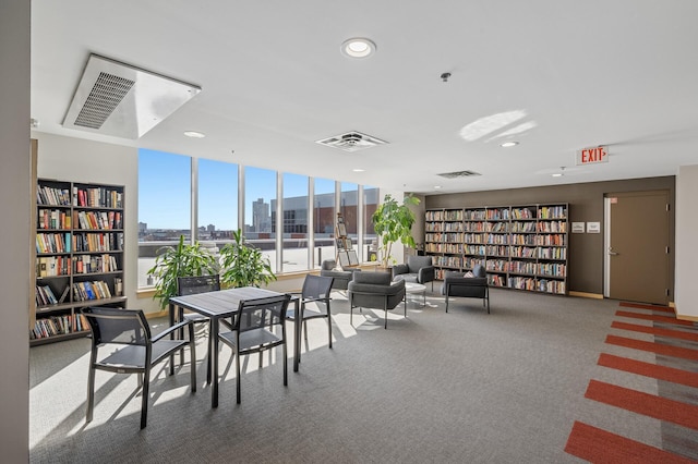 interior space with a view of city, visible vents, carpet, and recessed lighting