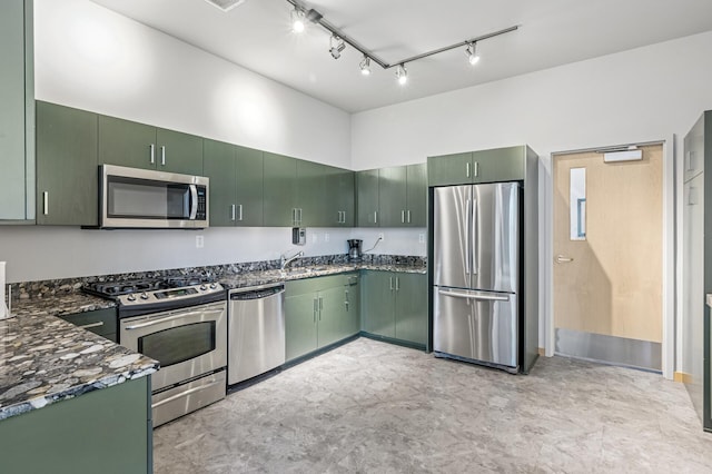 kitchen featuring stainless steel appliances, dark stone counters, and green cabinetry