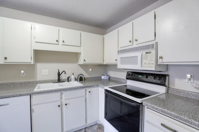 kitchen with white appliances, white cabinets, a sink, and a textured ceiling