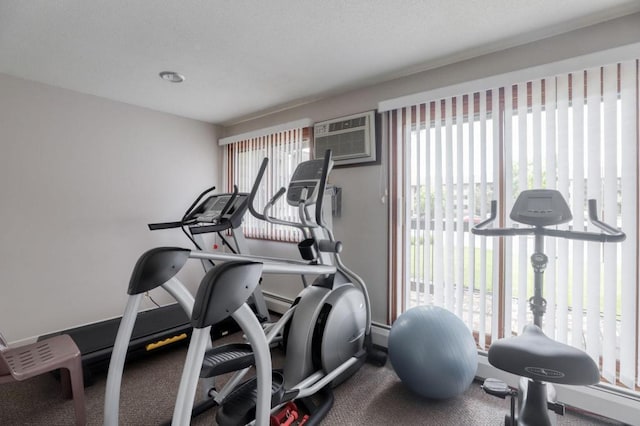 exercise area with a wall unit AC and baseboards