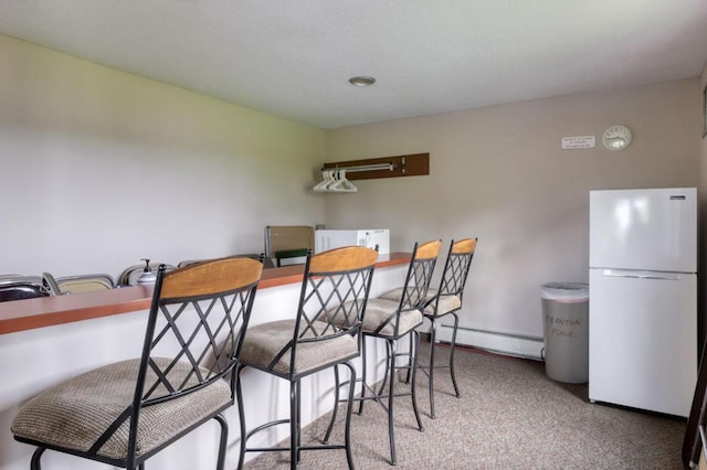 carpeted dining room with a baseboard radiator