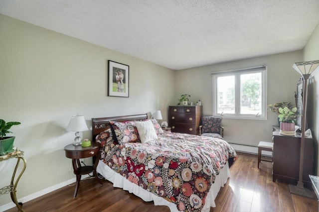 bedroom featuring a baseboard radiator, a textured ceiling, baseboards, and wood finished floors